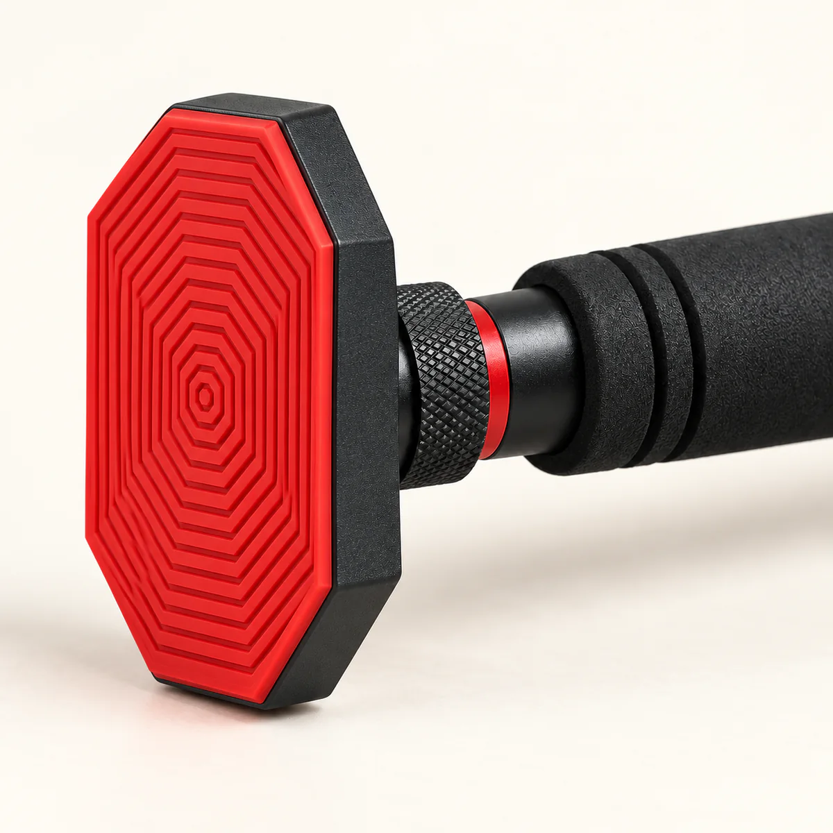 barre de traction porte sans perçage 3 | WO-Calisthenics Gros plan du patin octogonal rouge strié de la barre Lock Grip, de la molette de verrouillage moletée à bague rouge et de la mousse noire