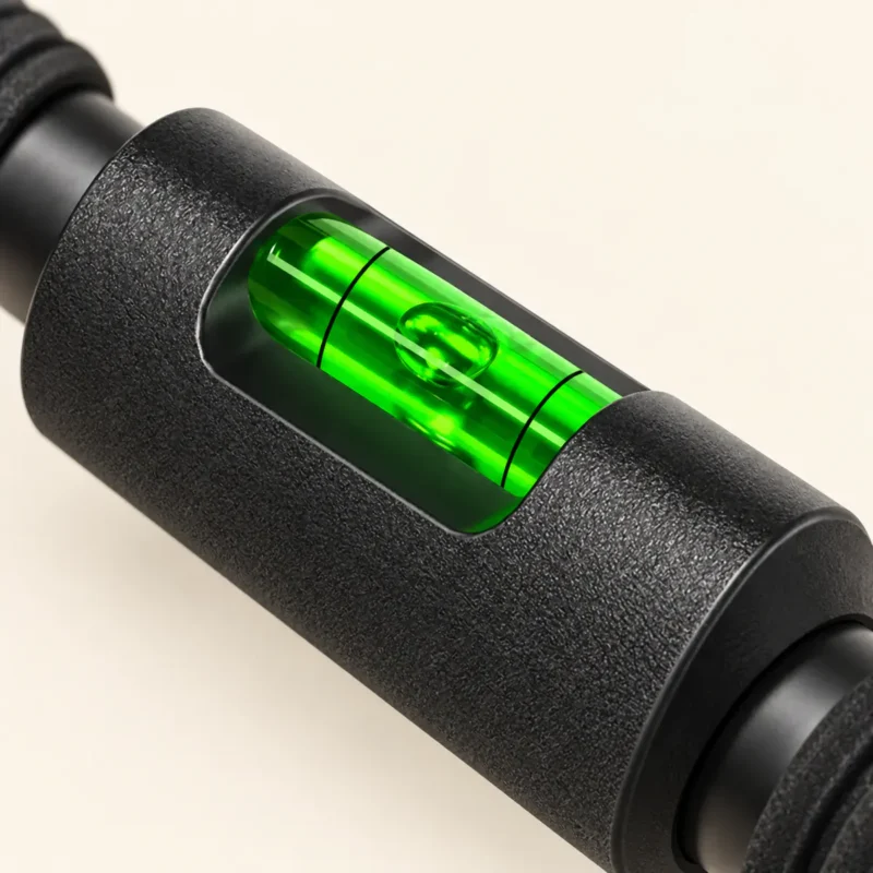 Gros plan du niveau à bulle au centre de la barre de traction Lock Grip : manchon noir texturé et fiole verte entre deux tubes et les mousses nervurées
